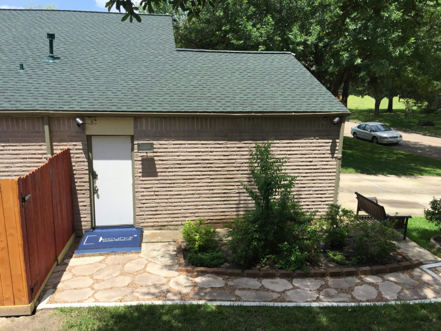 A small house with a garden and trees