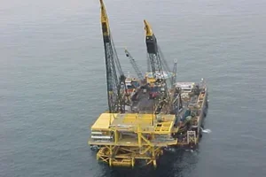 A large yellow and black rig in the ocean.