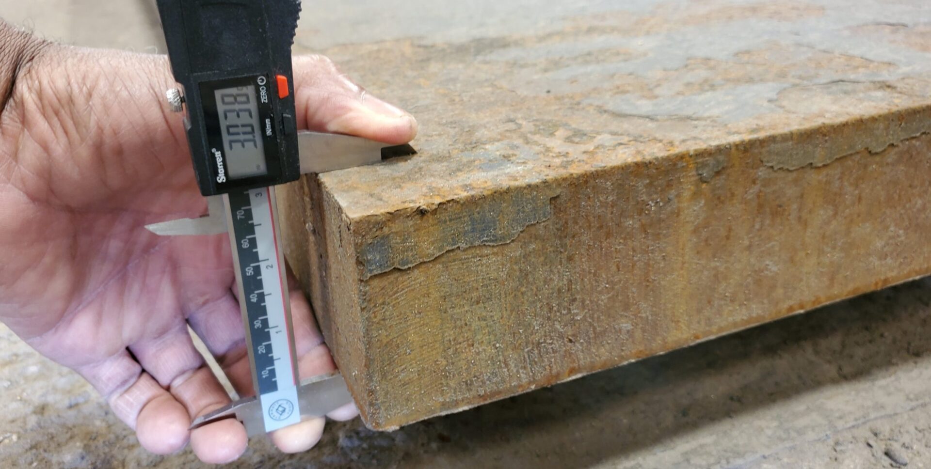 A person measuring the length of a piece of wood.