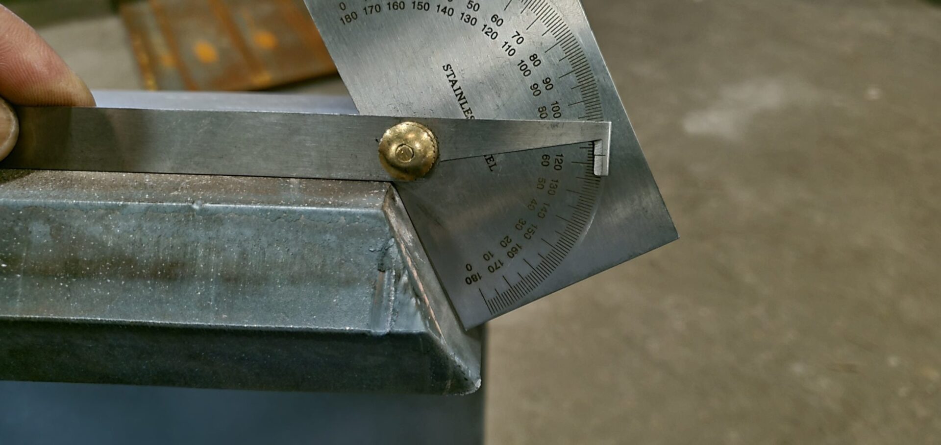 A metal object with a ruler and a brass knob.