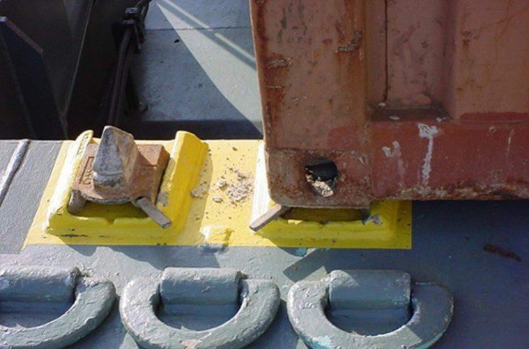 Rusty container corner on yellow metal chocks